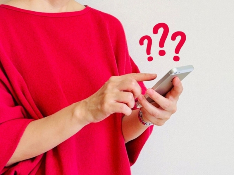 スマホで費用を調べる女性