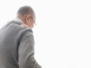 介護疲れで肩を痛める男性