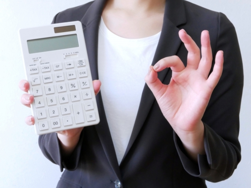 電卓で費用を出す女性